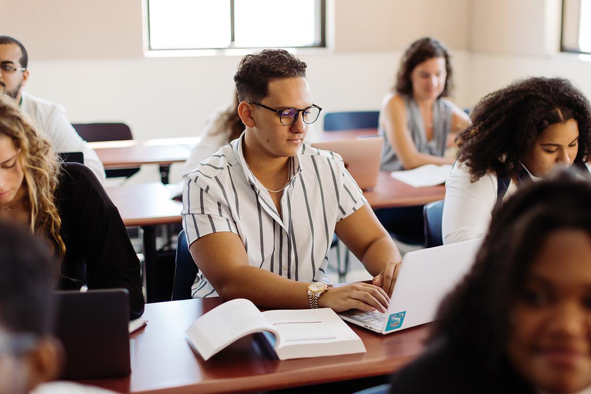 Student takes notes in an engineering concentration in electrical engineering class.