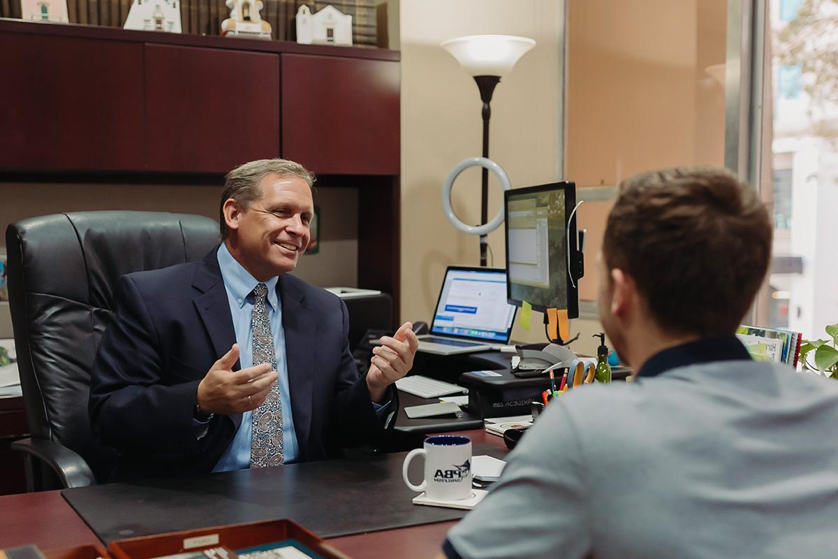 a faculty member speaking to a student in their office