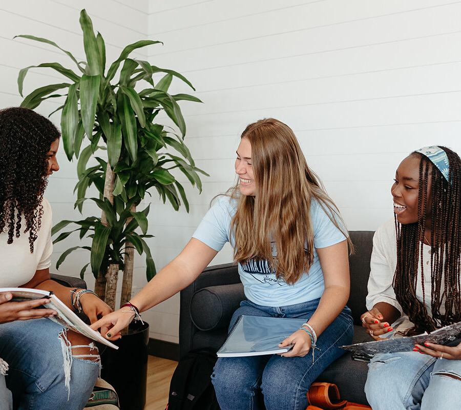 Three PBA students study together on campus.