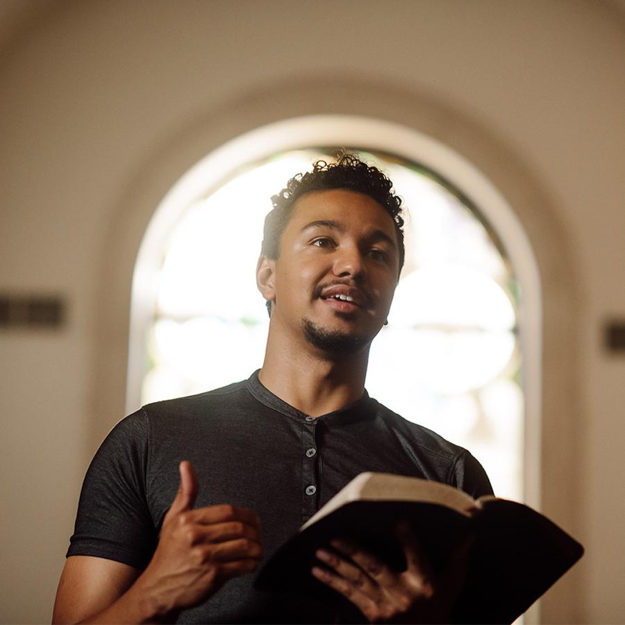 PBA student reads the bible at the front of chapel.